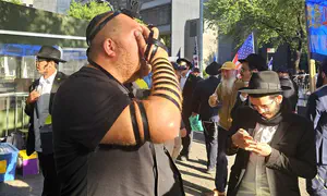 Hasidim from Brooklyn put tefillin on protesters outside UN
