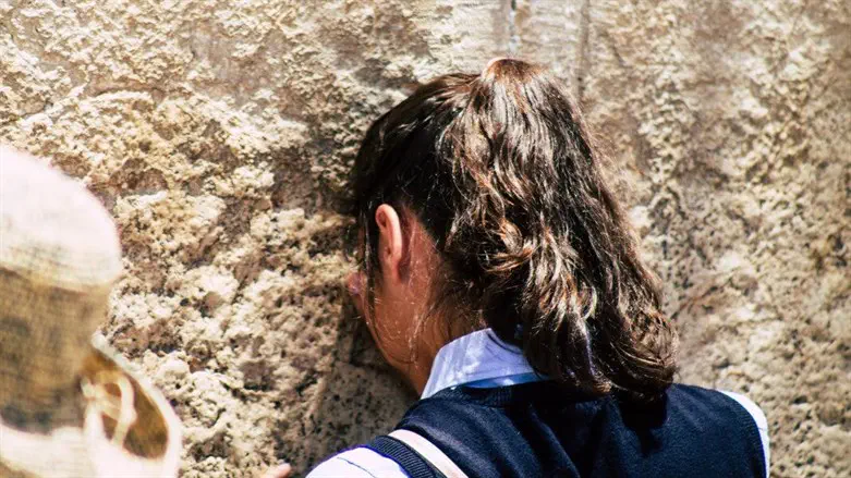 Jewish young woman praying at kotel