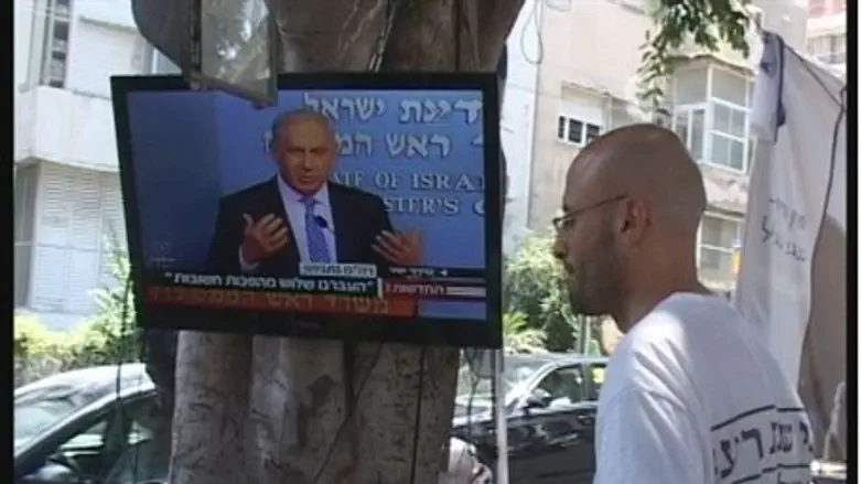 Tent protesters watch Netanyahu