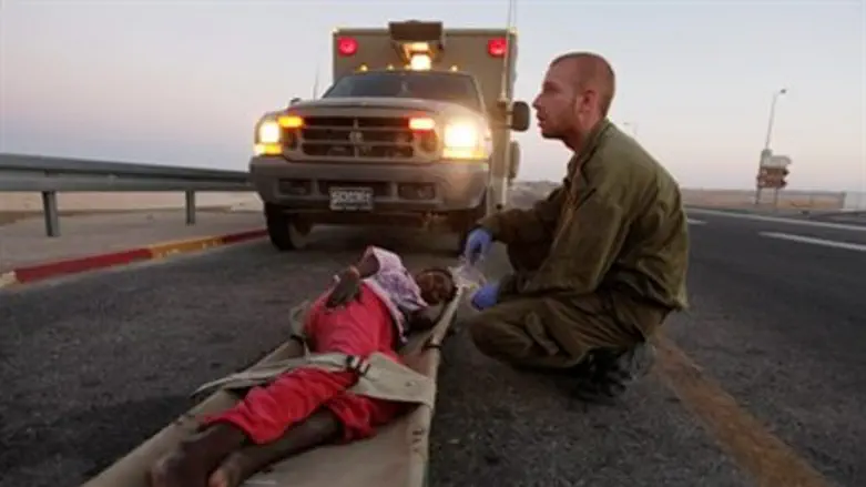 An Israeli soldier gives medical treatment to