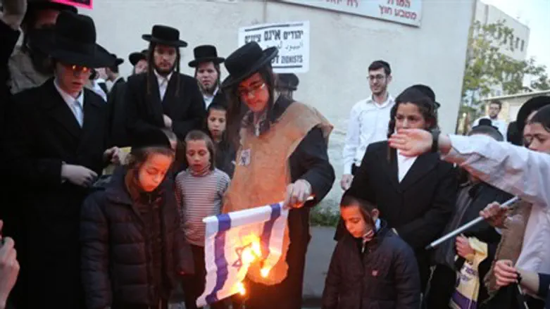 Neturei Karta members burn Israeli flag