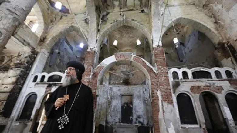 Coptic priest surveys damage to church wrough