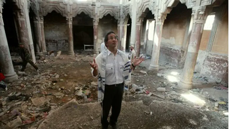 Jewish refugee David Gerbi prays in a ruined 