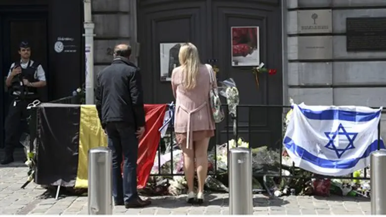 A couple stands by a memorial outside Brussel