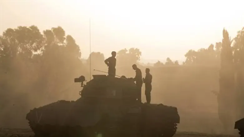 IDF soldiers stand atop an armored personnel 