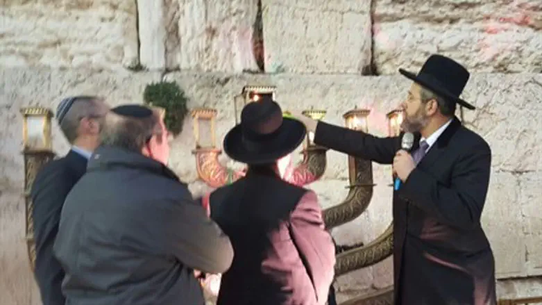 Rabbi Lau lighting the Hanukkiah at the Kotel