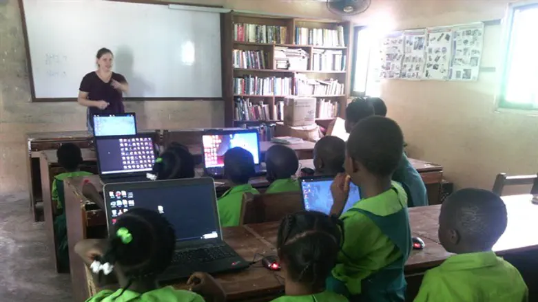 A Project TEN volunteer runs a computer class for children in a fishing village in Ghana