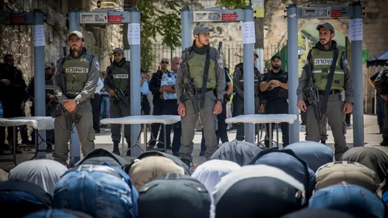 Muslim worshipers bow to soldiers while praying near Temple Mount