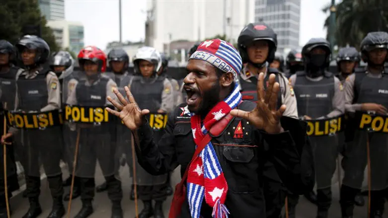 Activist shouts near police line during rally commemorating West Papuan independence