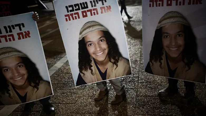 Protesters hold up signs with Ahuvya Sandak's picture