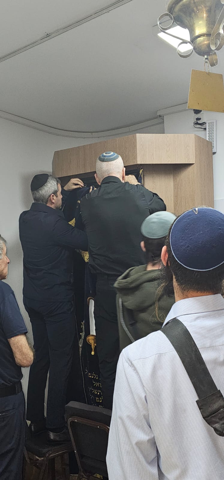 Yoav Gallant and his son hang the parochet