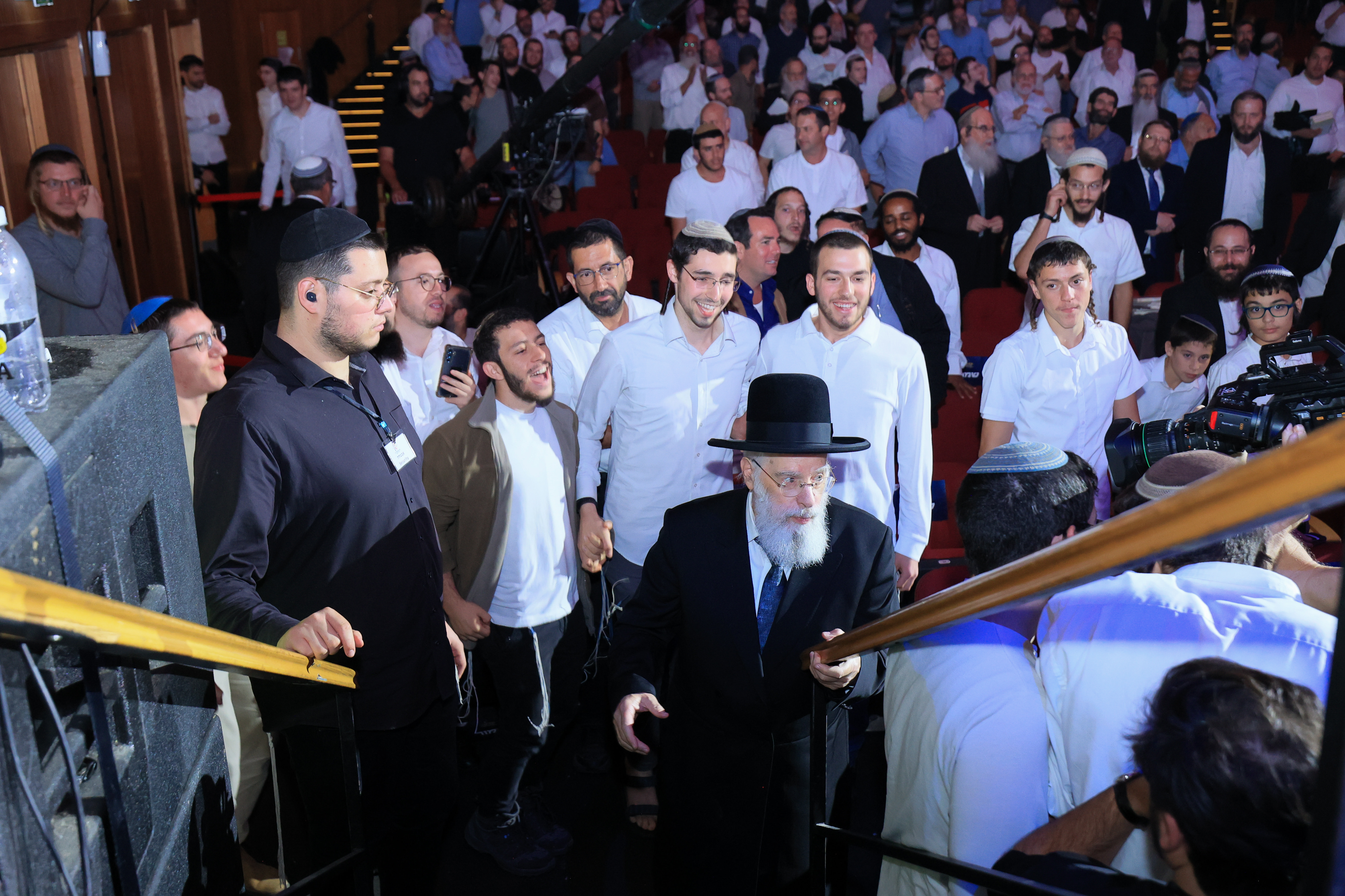 Merkaz HaRav Centennial: Students accompany the Rosh Yeshiva as he ascends the stage 