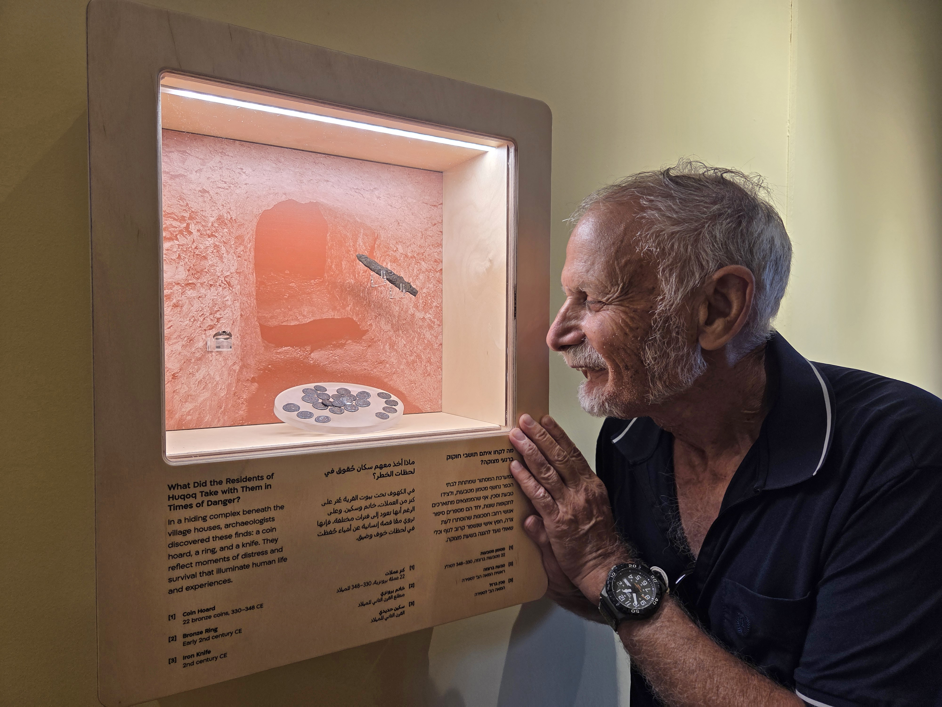 Prof. Yinon Shivtiel beside a coin hoard, an iron knife, and a bronze ring discovered in the hiding complex at Huqoq, during excavations by the Israel Antiquities Authority and Safed Academic College.