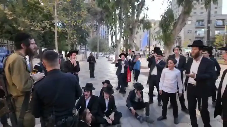 Protesters swarm haredi soldier, shout: "Traitor"