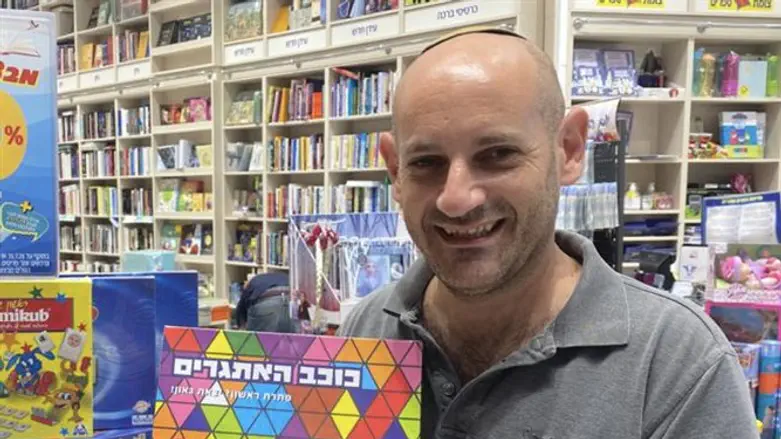 Aron Lazarus with the Hebrew version of his game, in a toy store