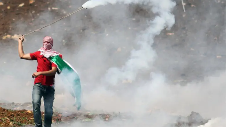 Arab rioter lobs tear gas on Nakba Day
