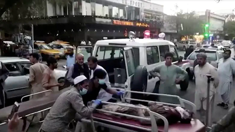 People carrying an injured person to a hospital after an attack at Kabul airport