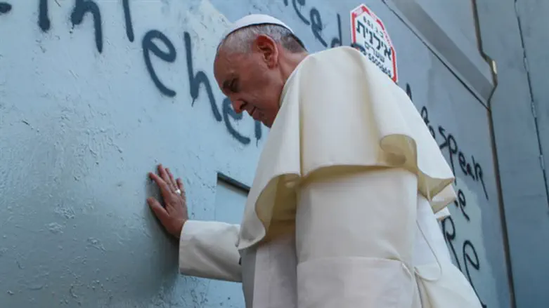 Apolitical? Pope Francis leans on security fence in prayer