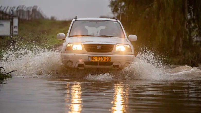 Vehicle crosses flooding stream on winter day in Golan Heights