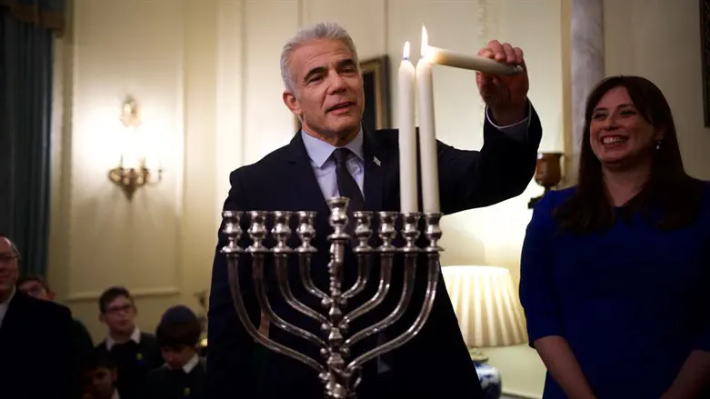 Lapid lights Hanukkah candle