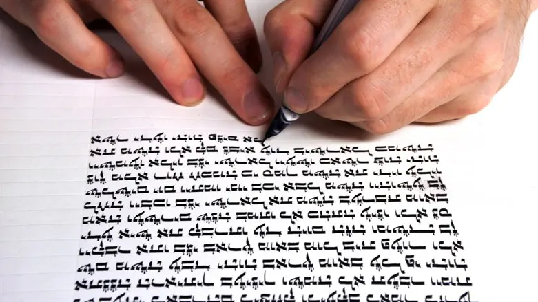 Scribe writing Torah scroll