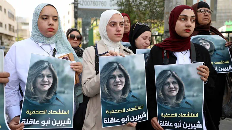 Women hold pictures of Shireen Abu-Aqlah