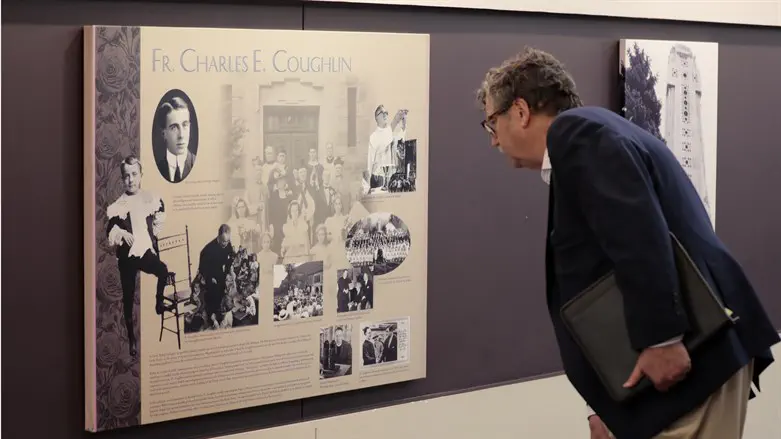 Levi Smith inspects a plaque discussing the history of Father Charles Coughlin