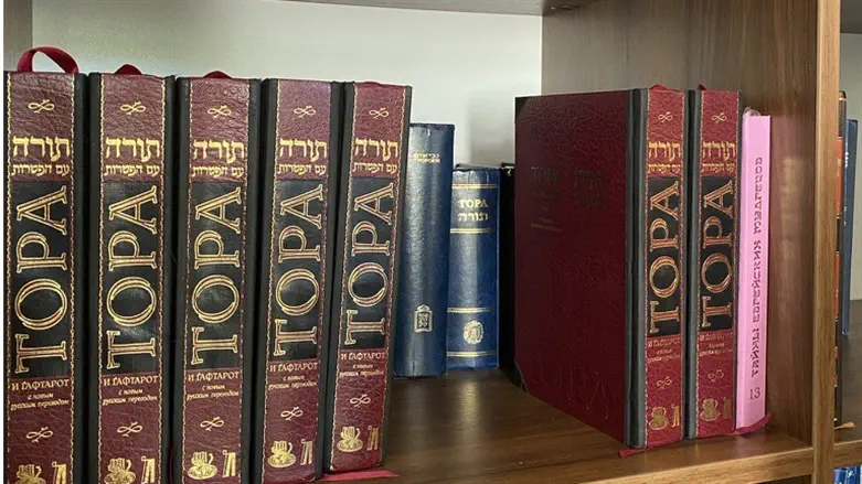 Books in both Hebrew and Russian sit on a bookshelf at Medzhybizh.