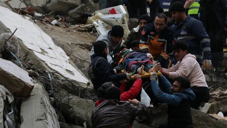 Rescuers carry out victim from ruins after earthquake in Adana, Turkey
