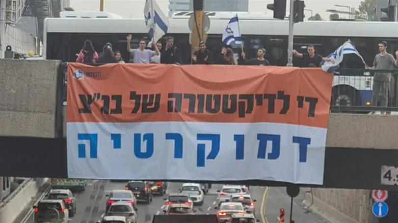Pro-reform activists hang a banner on an overpass in central Israel