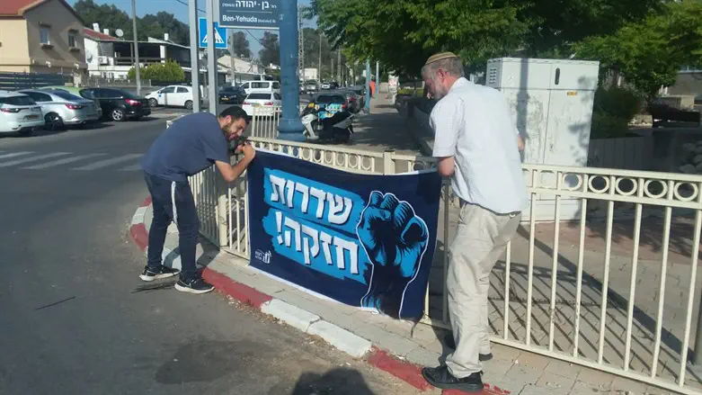 Sderot residents hang a sign stating "Sderot is strong"