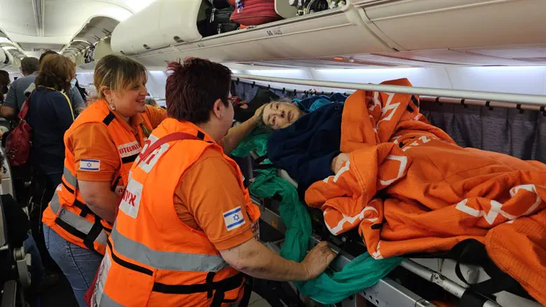 The elderly woman with United Hatzalah volunteers  on the plane to Israel