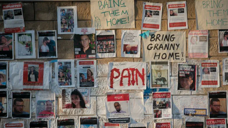 Photos of the hostages, on a wall in Tel Aviv