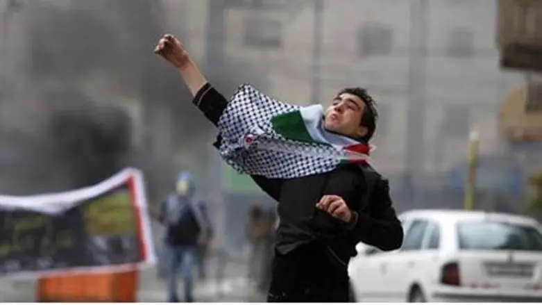 An Arab throws stones in Saturday's riots