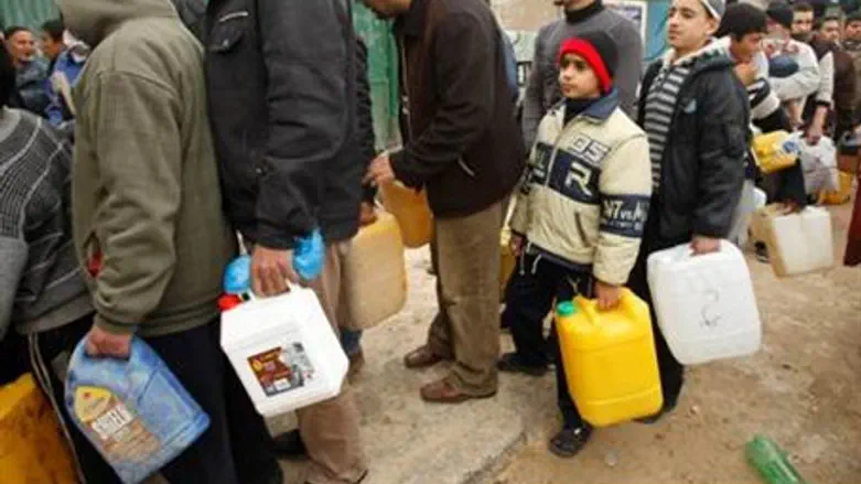 Gaza Arabs line up with fuel containers.