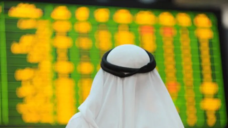 An Arab investor looks up at electronic board