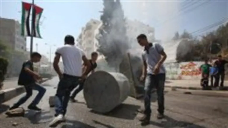 Arab youths erect a barricade in Hevron durin