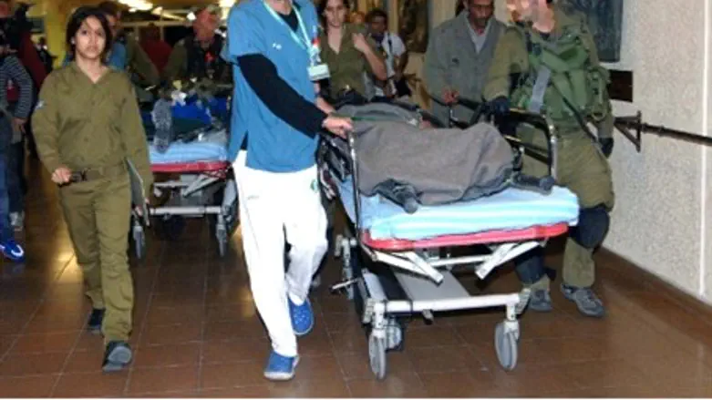 Wounded Israeli soldiers are wheeled into So