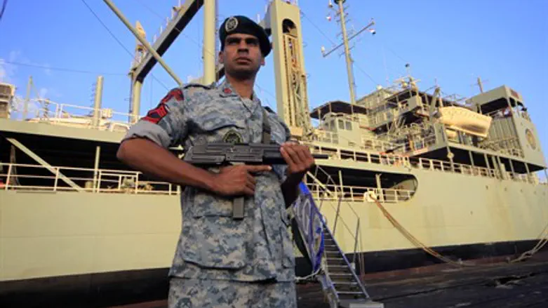 An Iranian soldier stands guard near Iranian Navy helicopter carrier (file)