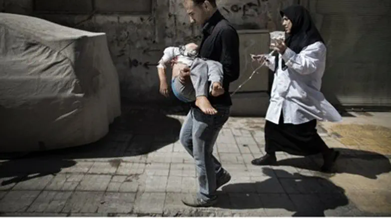A Syrian man carries his wounded daughter