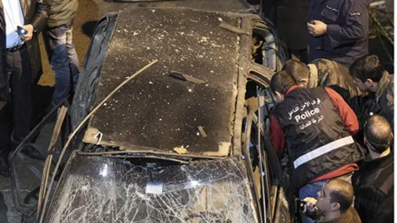 Security policemen inspect a damaged car in t