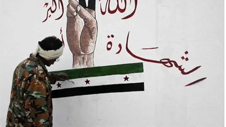 A member of the Free Syrian Army paints on th