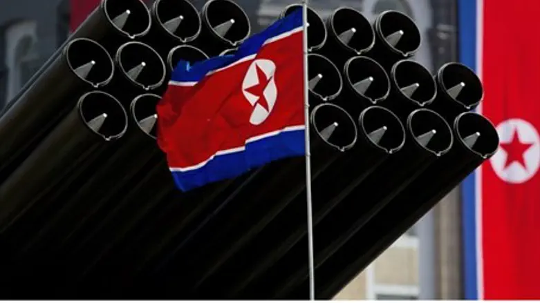 A North Korean flag flies before missiles 