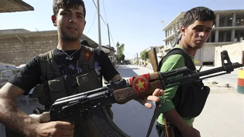 YPG fighter shows Kurdish flag on his gun