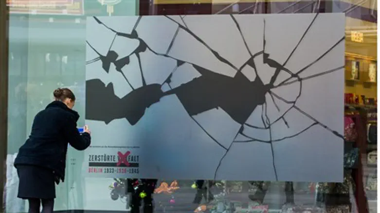 Woman affixes sticker to shop window as part