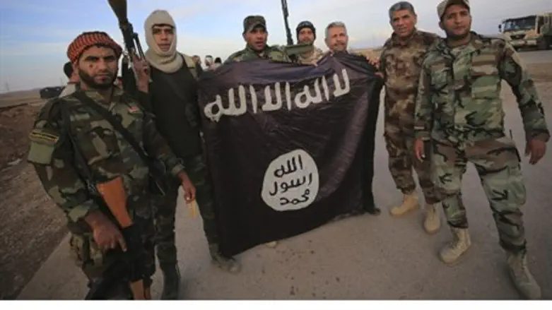 Iraqi Shi'ite fighters pose with captured ISIS flag (file)