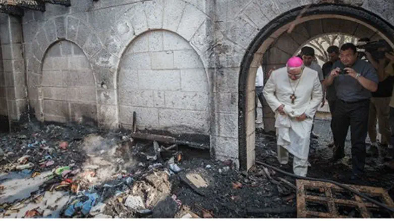 A priest inspects the damage at the Church of the Multiplication at Tabgha, on the Sea of 