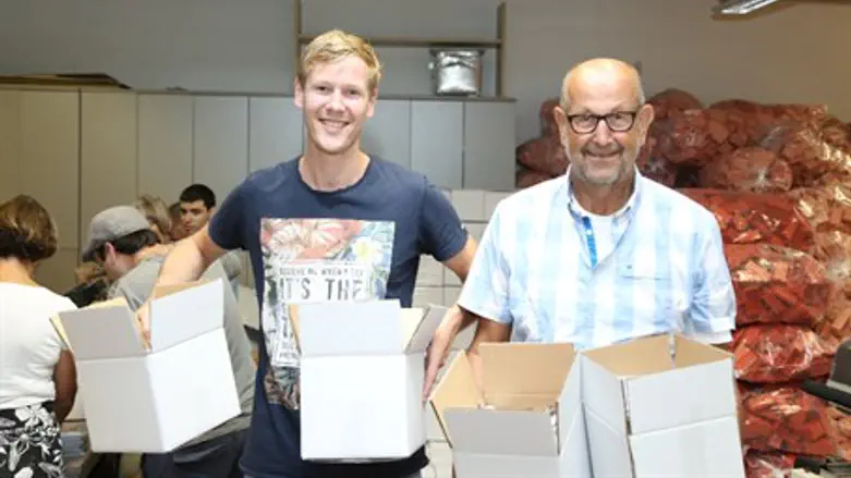 Lev Haolam volunteers packing boxes to be sent out to customers