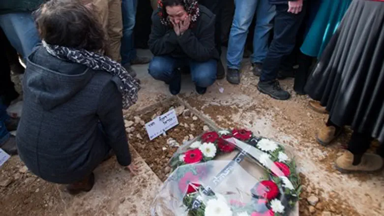 Mourners place flowers on Dafna Meir's grave