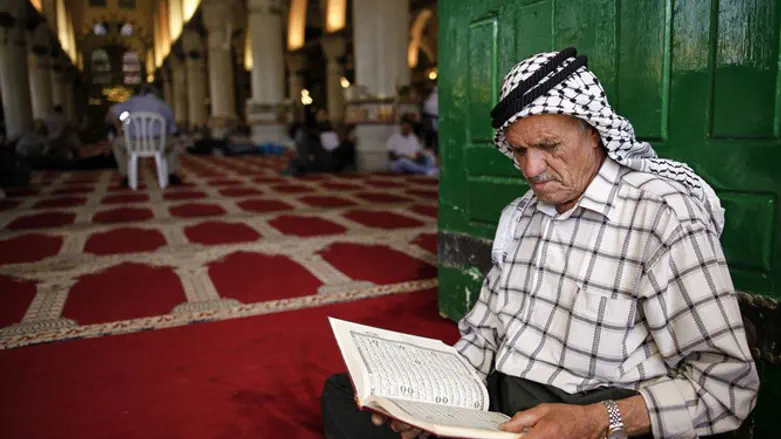 Muslim man reads the Koran during Ramadan at Al Aqsa Mosque
